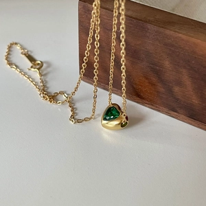 925 silver heart necklace with green crystal stone on elegant wooden display