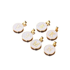 Detail of round golden stainless steel letter pendants with shimmering shell inlay effect