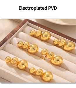 Detail of three-sphere gradient gold stud earrings with PVD vacuum plating finish