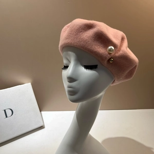 Detail of pink wool beret with side pearl and gold bead accents on a model head