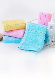 Detail of 30x70cm cotton towels in yellow, pink and blue showing 14S yarn texture