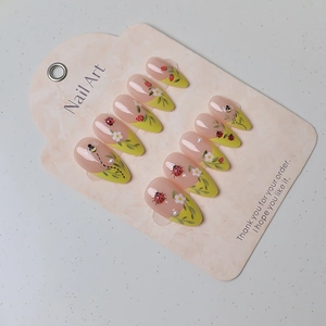 Detail of almond press-on nails with hand-painted ladybugs, bees and pearls