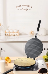 Close-up of non-stick round egg roll maker pan with grid texture on portable gas stove