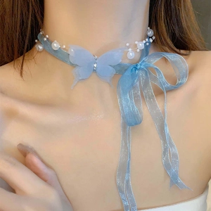 Detail of light blue butterfly choker with delicate ribbons and white pearls on neck
