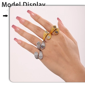 Detail of snake-shaped rings in gold and silver with colorful inlaid stones on fingers