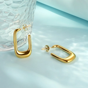 French U-shaped gold stainless steel earrings displayed with texture glass and water shadows