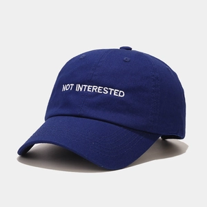 Detail of white embroidery text on a navy blue cotton baseball cap with clean stitching