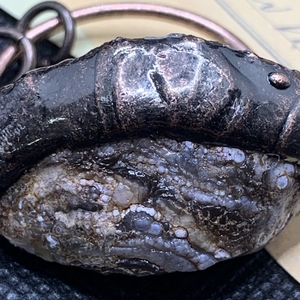 Vue macro d'un pendentif géode d'agate vintage avec détails en bronze antique
