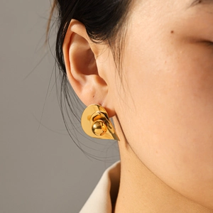 Close-up macro shot of irregular gold stainless steel stud earring on an Asian model