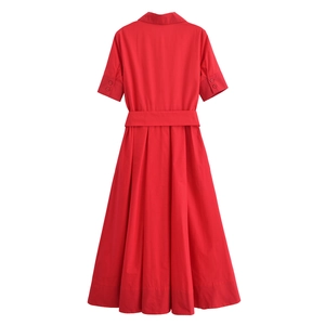 Detail of red poplin midi dress featuring shirt collar, tied belt and pleated skirt hem