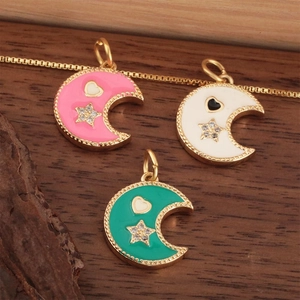 Colorful enamel moon star heart pendants in pink, white, and green on wooden background