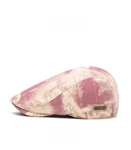 Side view of a vintage pink tie-dye beret hat featuring a leather GSIOR brand patch