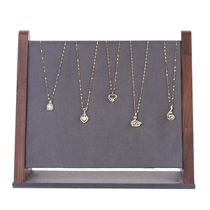 Walnut wood necklace display stand with gray backboard holding five gold pendants