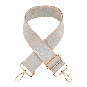 Close-up of light blue floral embroidery guitar strap with gold metal swivel hooks