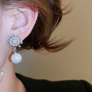Detail of snowflake pearl earring with cubic zirconia on a model for elegant style