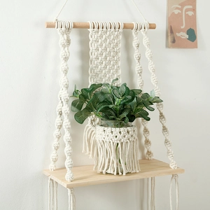 Detail of hand-woven cotton rope macrame shelf featuring a natural wood floating board