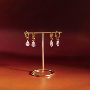 Close-up of gold stainless steel hoop earrings with teardrop and marquise cubic zirconia