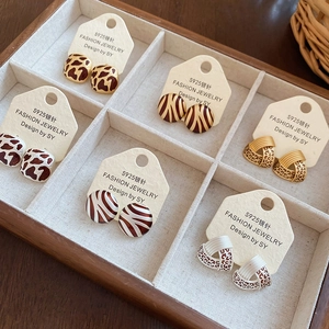 Set of six vintage geometric earrings with animal prints in a wooden display tray