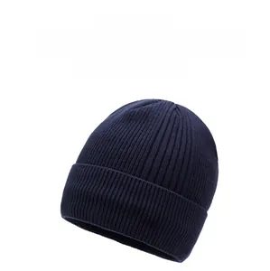 Macro detail of dark blue ribbed knit texture and logo label on winter beanie