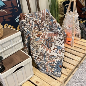 Close-up of bohemian woven camping blanket with geometric patterns and fringe edges