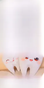 Gros plan de coussins en peluche en forme de dents avec expressions brodées
