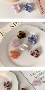 Macro view of assorted 2cm colorful acetate mini hair claws with metal spring detail