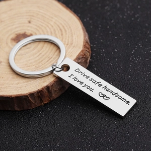 Macro detail of silver rectangle keychain engraved with Drive Safe Handsome I Love You text