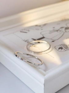 Close-up of S925 sterling silver hoop earrings with sparkling texture on a white frame
