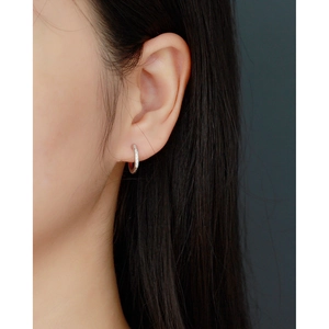 Close-up of S925 silver hoop earrings with clear stones worn on a model's ear