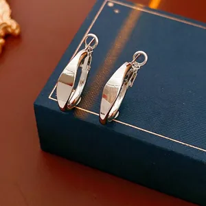 Minimalist silver hoop earrings with a polished mirror finish on a premium jewelry box