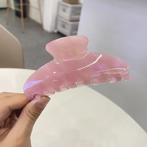 Macro detail of a large pink acetate hair claw with elegant marble texture pattern