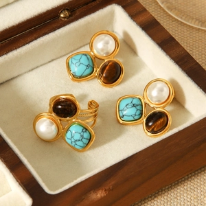 Detailed shot of vintage gold stainless steel jewelry set with turquoise and tiger eye stone