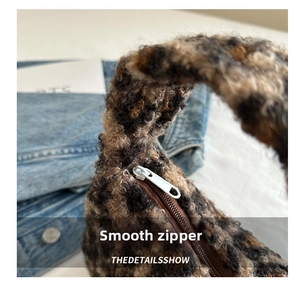Detail showing the smooth white zipper closure on the leopard print faux fur plush handbag