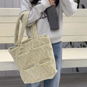 Close-up of plush tote bag texture with colorful dots and functional four front pockets