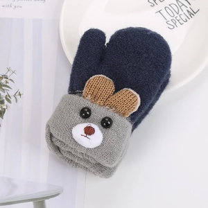 Detailed macro view of dark blue knit baby mittens with cute 3D bear ears and embroidery