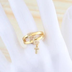 Detail of gold safety pin ring featuring a cross charm and micro-paved white zircons