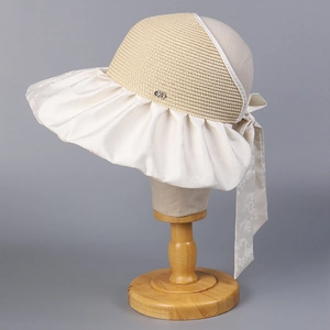 Détail d'un chapeau de soleil à large bord avec nœud en satin jacquard et paille tressée