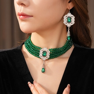 Detail of vintage emerald green beaded choker and teardrop earrings set on a model
