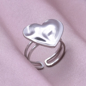 Detail of silver heart ring with molten lava texture on silky pink fabric