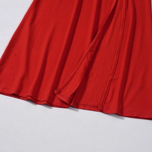 Detail view of the hem and stitching on a vibrant red bodycon dress with split design