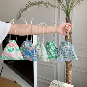 Close-up of floral cotton drawstring pouches with five patterns on a person's arm