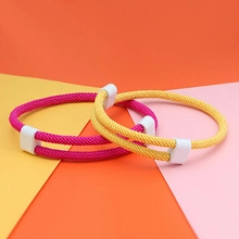 Close-up of pink and yellow magnetic couple bracelets with double braided cord design