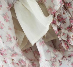 Detailed macro view showing the double-layer lining and hem of floral chiffon dress
