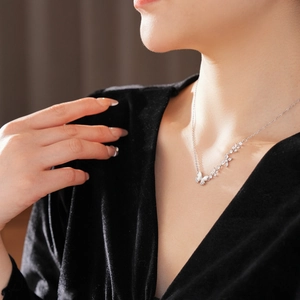 Gros plan d'un collier papillon en argent avec zircon et nacre sur le cou d'une femme