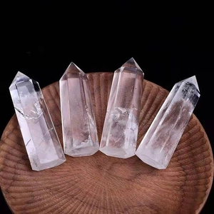Set of four natural clear quartz hexagonal crystal points on a rustic wooden tray