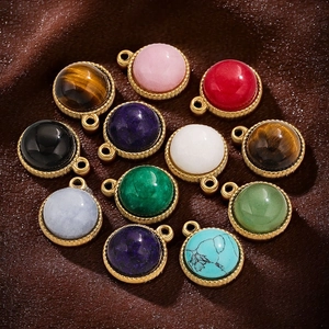 Polished round natural stone pendants with gold plated rims on brown velvet