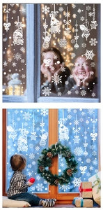 Detail of white Christmas window decals showing snowflakes and Santa Claus on glass