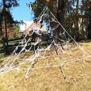 Giant white triangular spider web and large black furry spider for Halloween yard decor