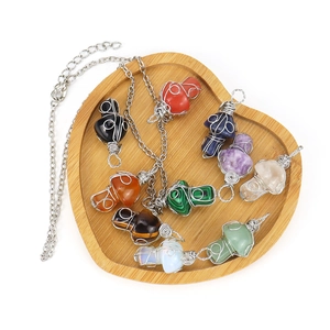Macro shot of assorted crystal mushroom pendants with wire wrapping in a heart wooden tray