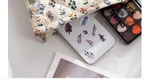 Detailed view of quilted floral makeup bag holding a tablet and eyeshadow palette